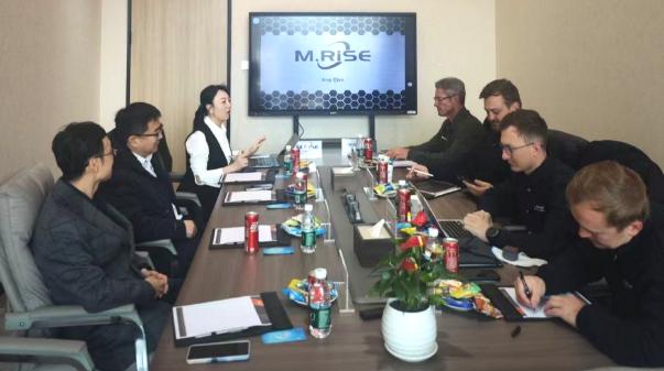 M.RISE sales team discussing a customized industrial cutting machine solution with South African customers in the company meeting room.