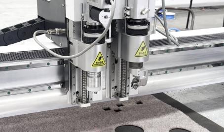 M.RISE carpet cutting machine tool head combining an oscillating knife and rotary knife for different carpet structures and backing materials.