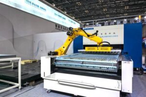 MRISECNC robotic unloading and stacking solution using a vacuum gripper to handle parts from a REEGAO coil-fed laser blanking line.